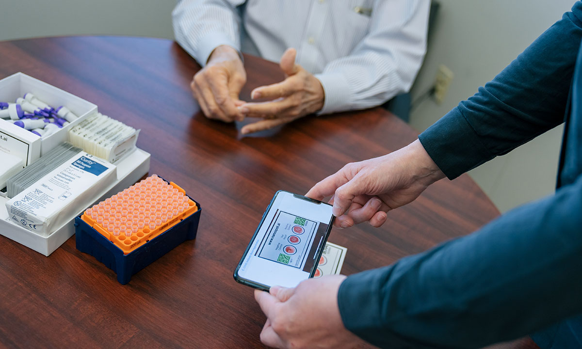 Close-up of someone taking a picture of the NanoSpot.AI rapid COVID-19 antibody test card.