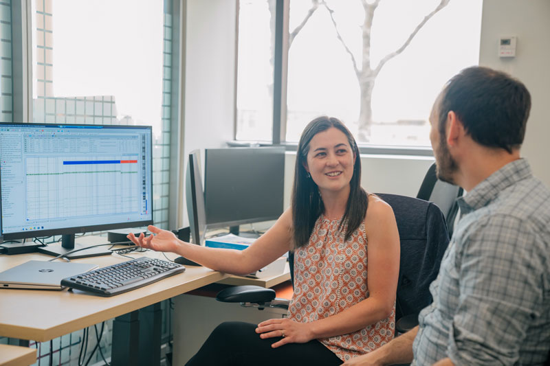 A man and a woman sit at a computer