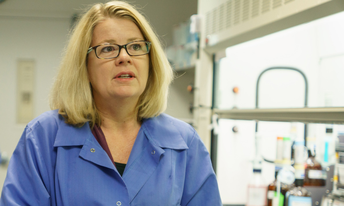 Gwen McMillin stands in a laboratory.