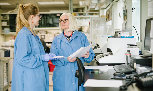 Marzia Pasquali talks with a colleague in a laboratory.