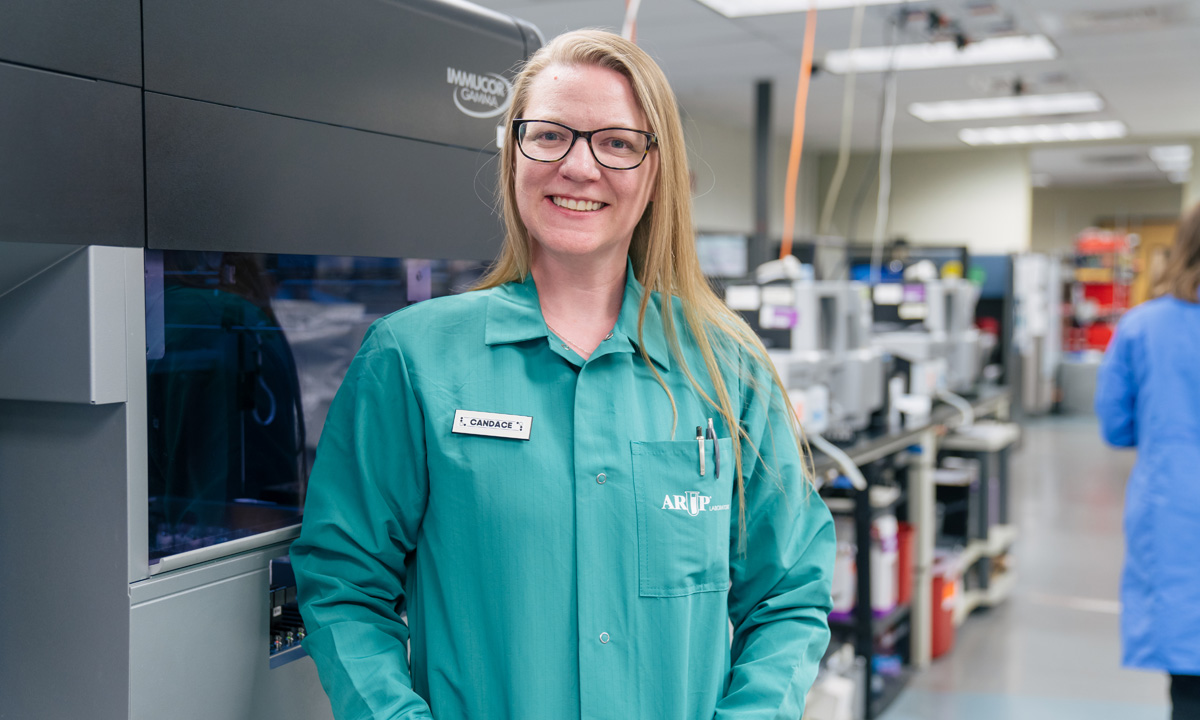 Candace Thomas stands in front of a machine in ARUP transfusion lab