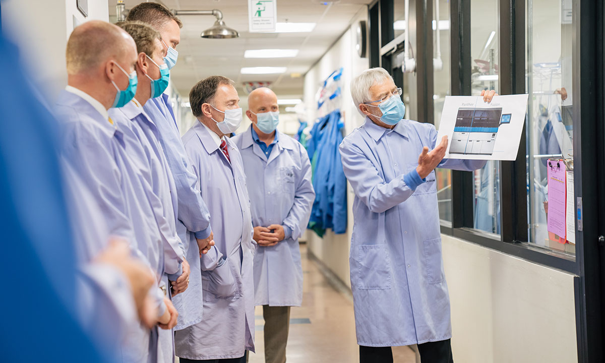 David Hillyard explains instrumentation used for COVID-19 molecular diagnostic tests to a group touring the lab