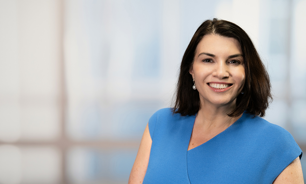 Dr. Tracy George stands in front of a blurred window.