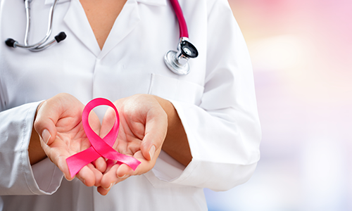 a clinician holds a pink ribbon