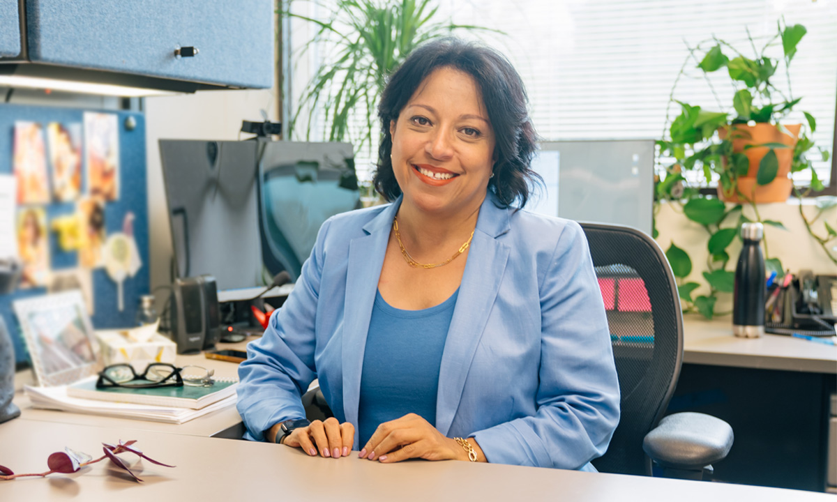 Sherin Shaaban, MD, PhD, MSci, FACMG, sits at her desk in her office.