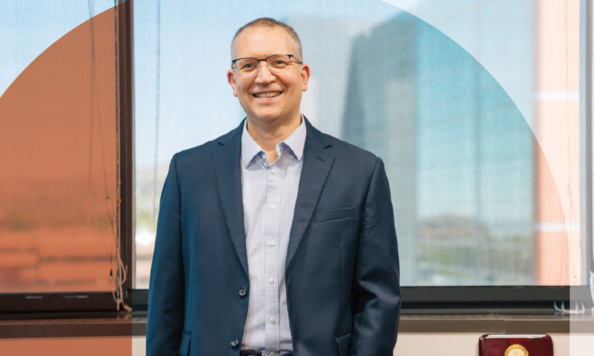 Dr. Jonathan Genzen stands in front of an officce window.