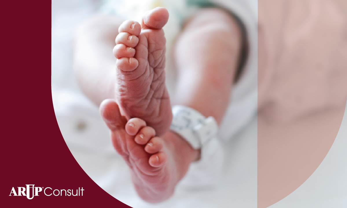 Image of newborns crossed feet with a hospital ID tag around the left ankle.