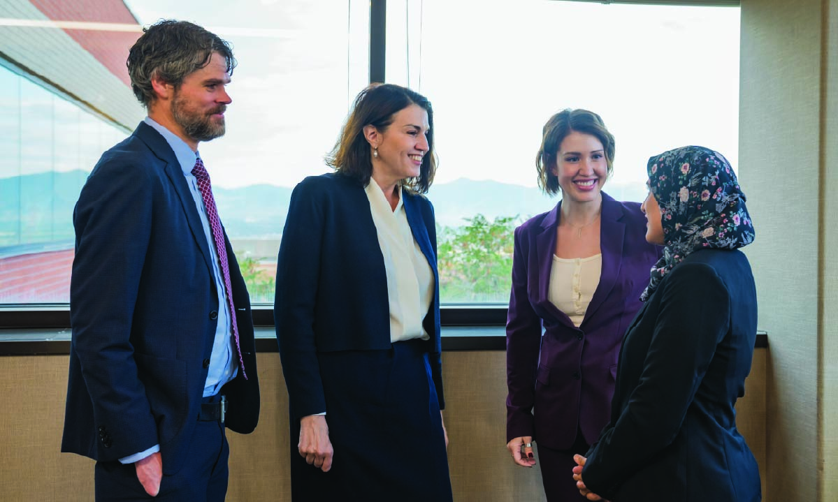 Pictured from left to right are Hunter Best, Tracy George, Erica Clyde, and Salika Shakir talk. The window behind them shows the ARUP campus.
