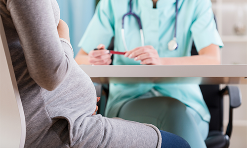 Clinician sitting across from pregnant woman