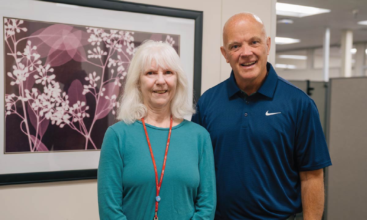 Karen Brisendine, left, and Andy Theurer stand in front of a flower X-ray art print.