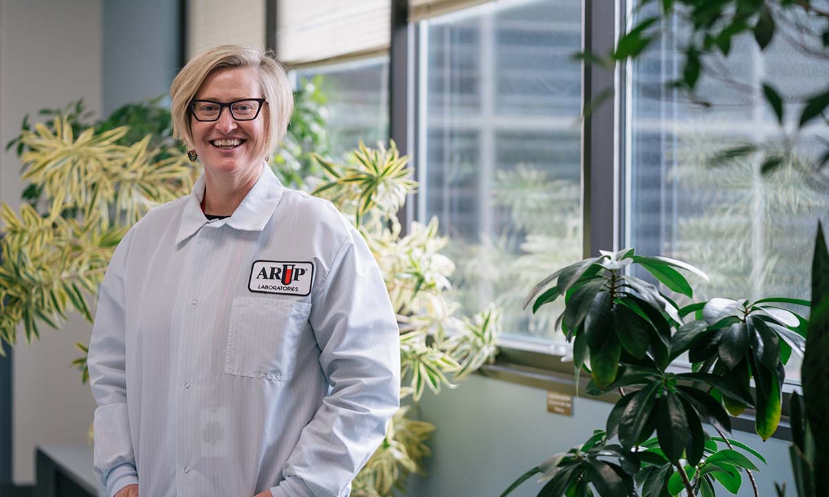 Kim Hanson stands in front of a window in an office