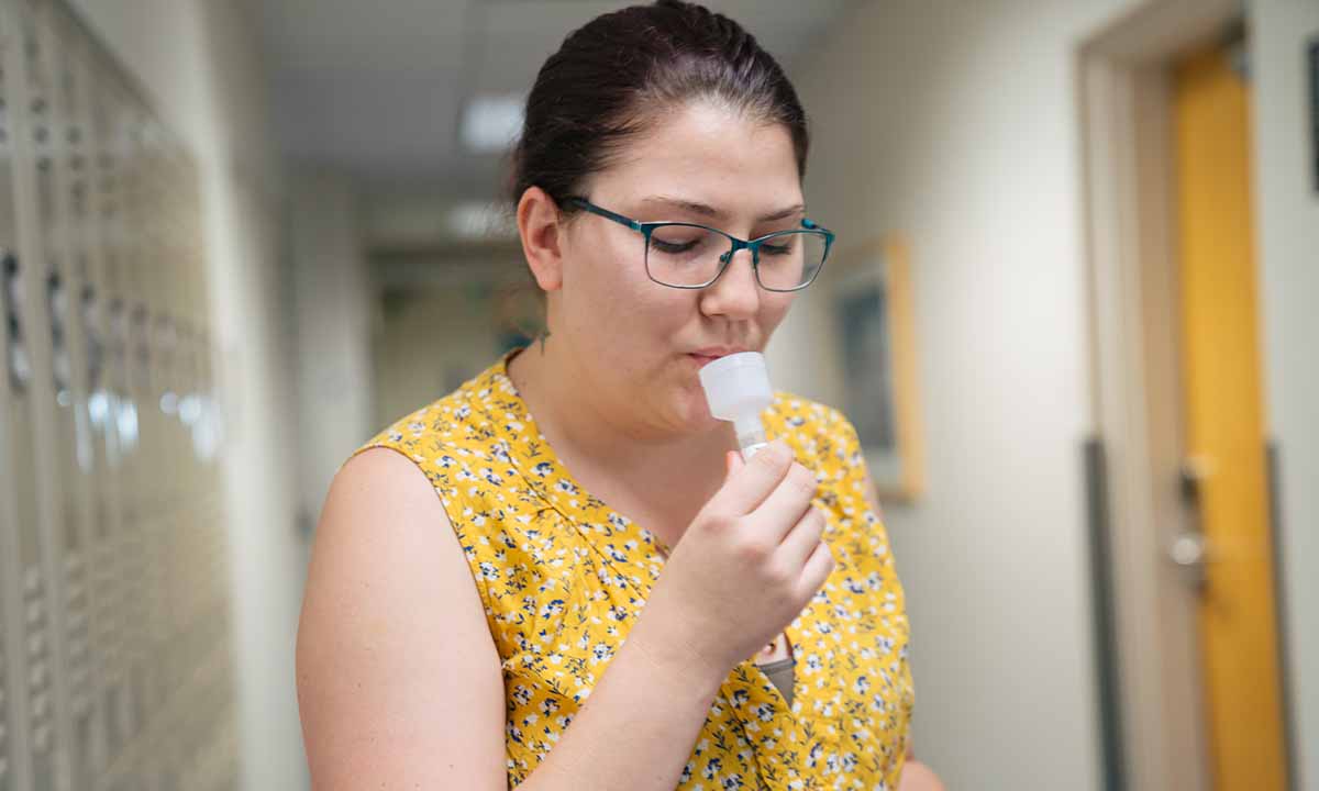 A woman collects a saliva sample