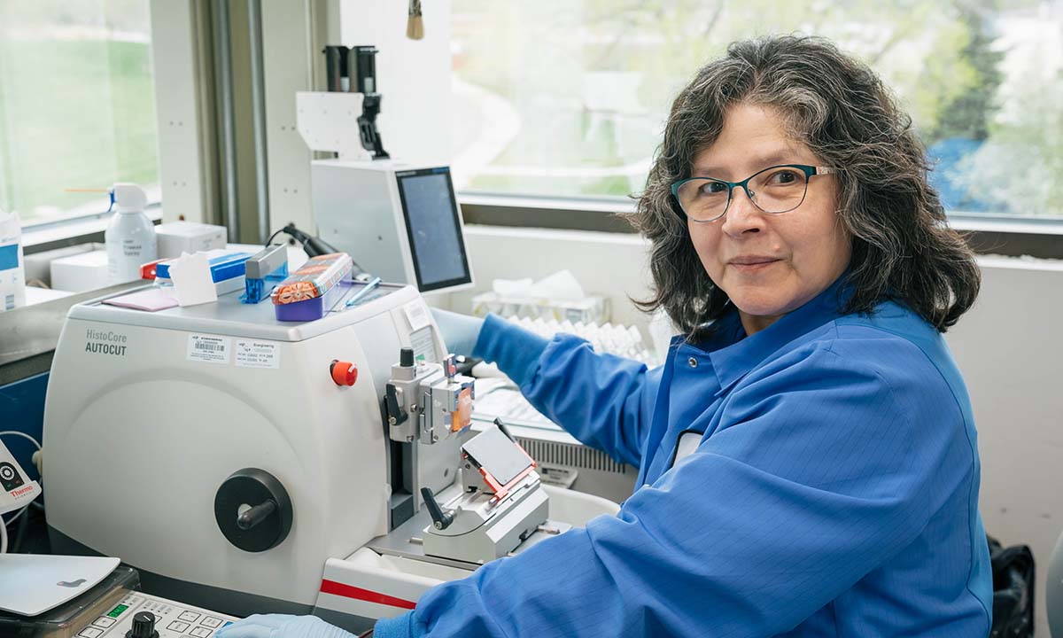 Maritza Byczkowski sits at a lab instrument, preparing tissue sample slides