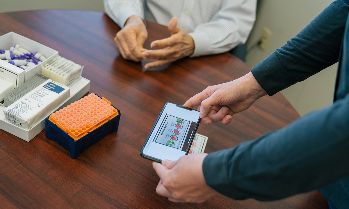 A person holds a phone showing a COVID test