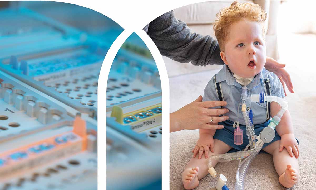 Cal Taylor sits with the help of an adult. Tubes run down his chest.