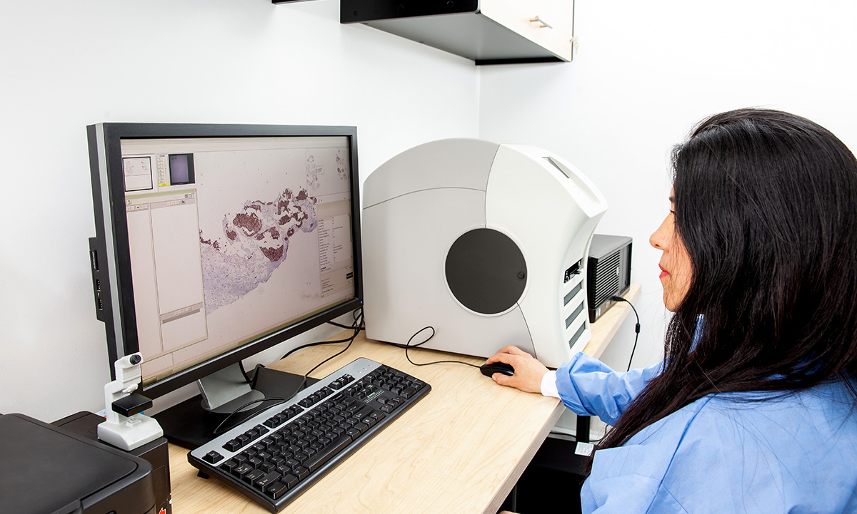 A clinician works at a computer