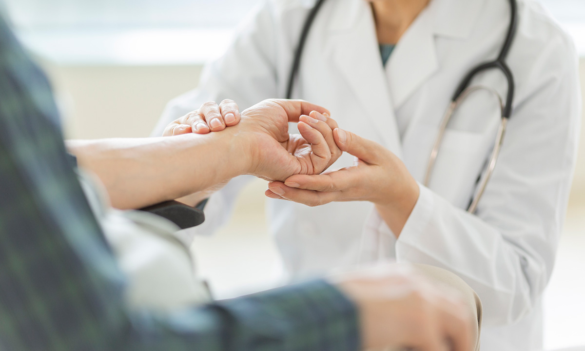 A clinician checks a patient's pulse.