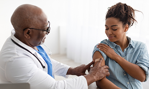 A clinician gives a vaccination to an indifidual