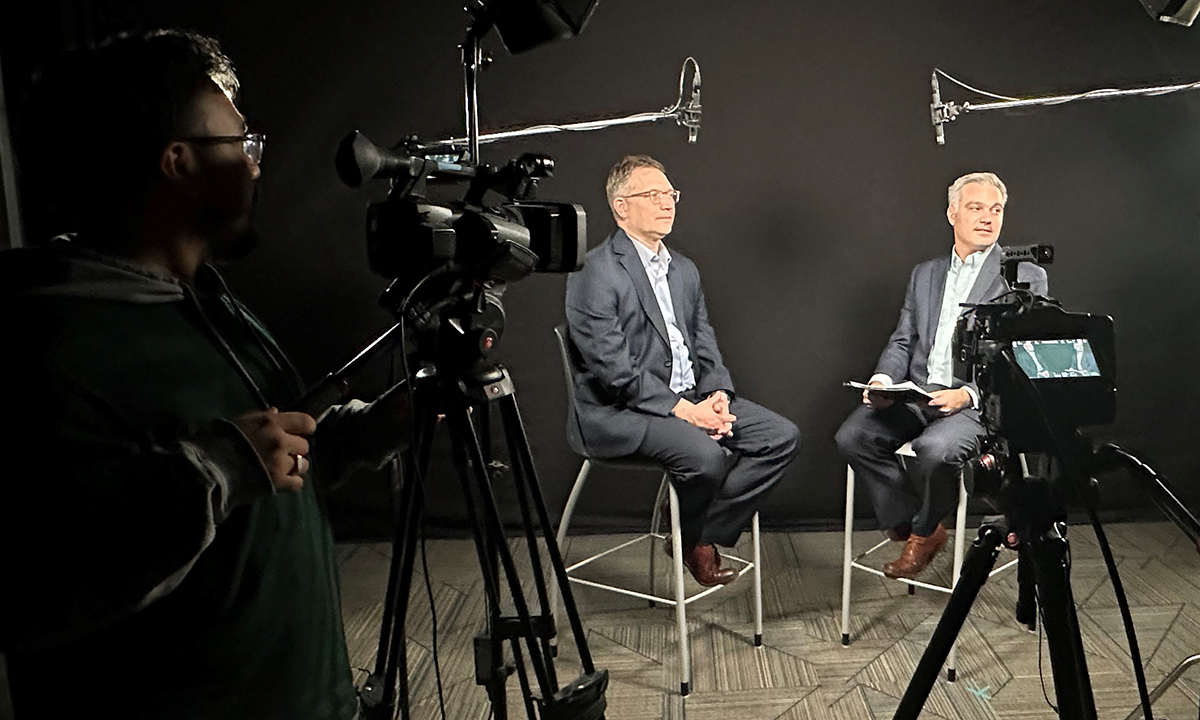 Jonathan Genzen, left, and Jonathan Carr sit in a studio.