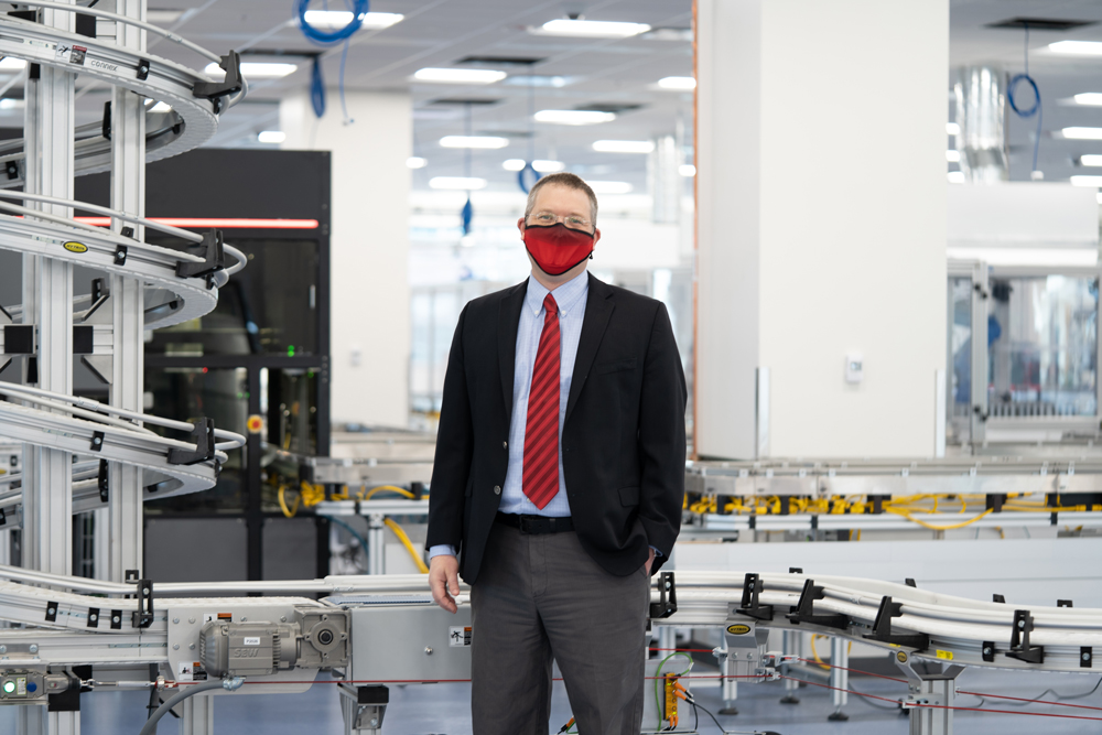 ARUP Chief Operations Officer Jonathan Genzen stands in front of automated lab equipment