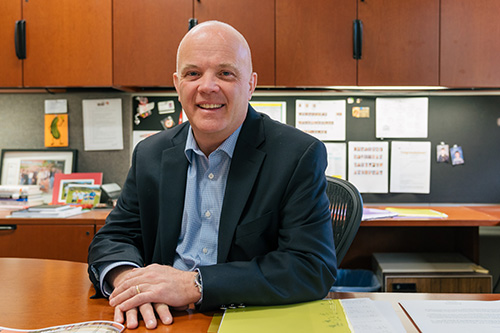 Andy Theurer sits at the desk in his office