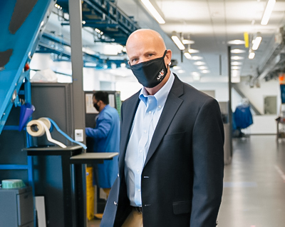 Andy Theurer stands in the lab wearing a face mask