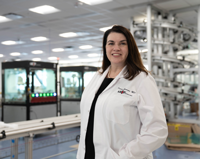 Tracy George stands smiling in the lab