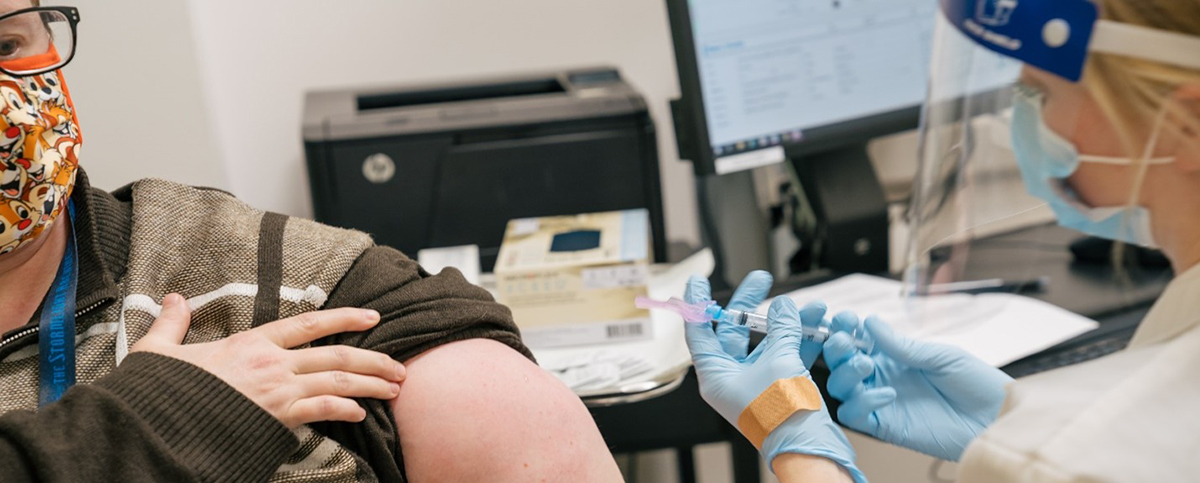 An ARUP Family Health Clinic employee administers a SARS-CoV-2 vaccine to an employee in the clinic