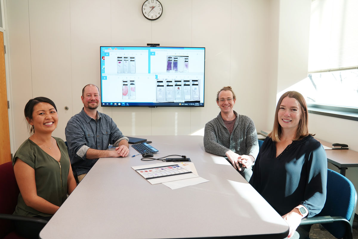 The Clinical Trial group sits around a table in a meeting room