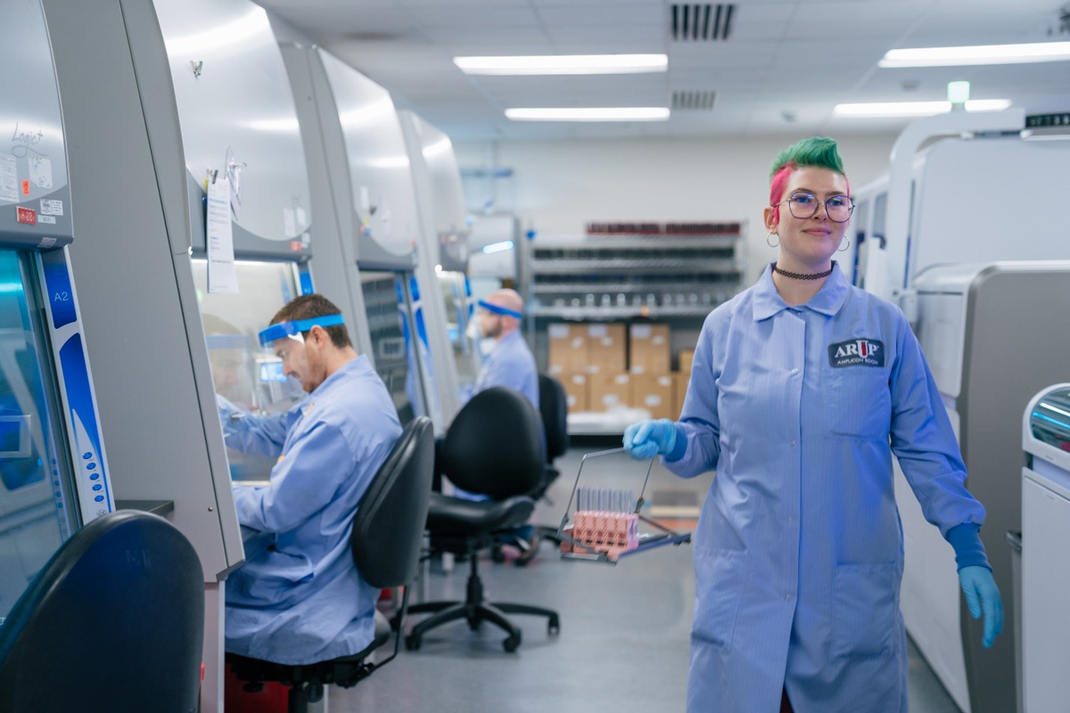 A woman carries samples in a lab