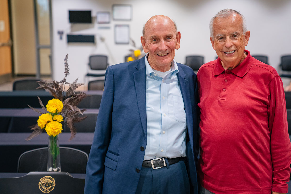 Mark Astill and Harry Hill stand next to each other in a conference room