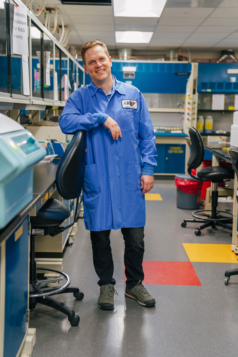 Devin Close leans on a chair in the lab