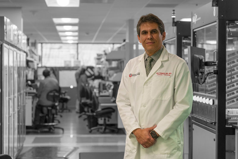 Julio Delgado stands in front of lab equipment