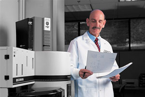 Harry Hill looks at a sheet of paper in front of lab equipment