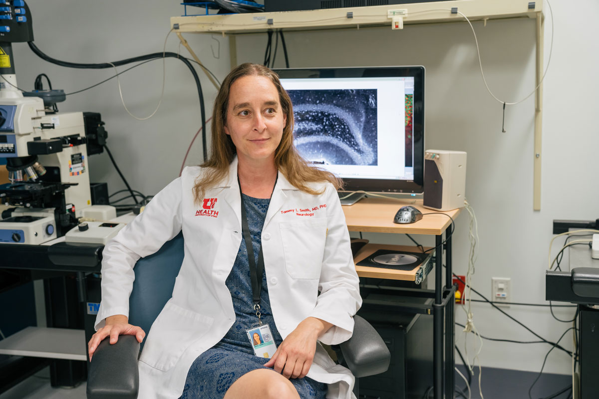 Tammy Smith sits in front of lab equipment and a computer screen