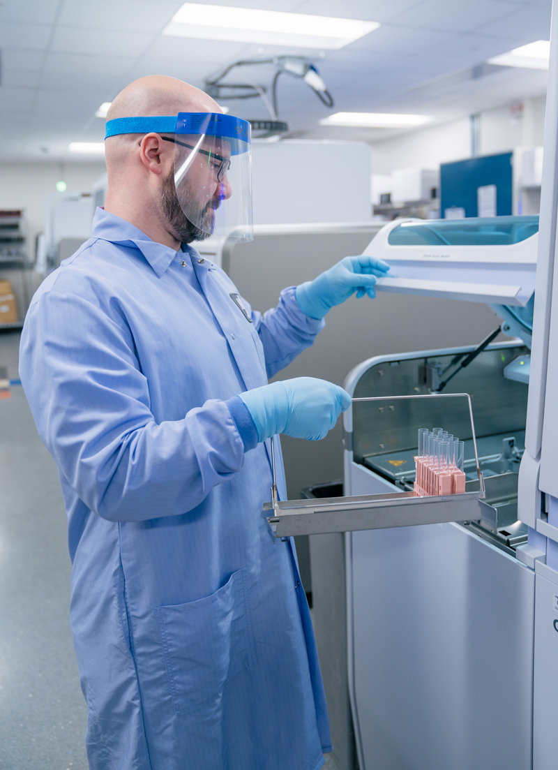 A lab technician with a tray of specimens