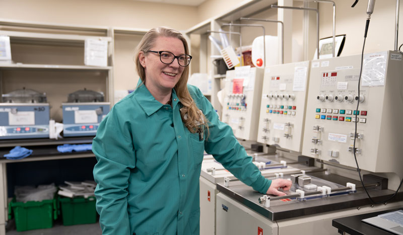 Thomas smiles next to specialized instruments