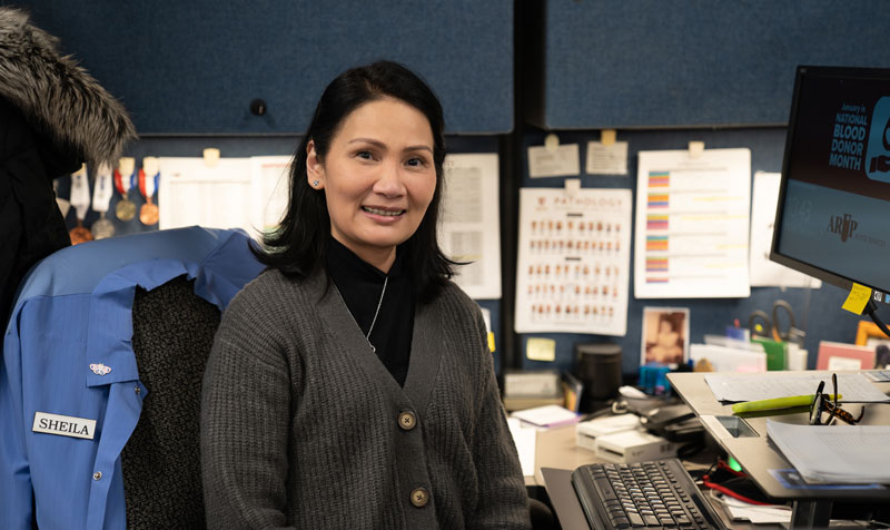 Villanueva smiles while sitting at her desk