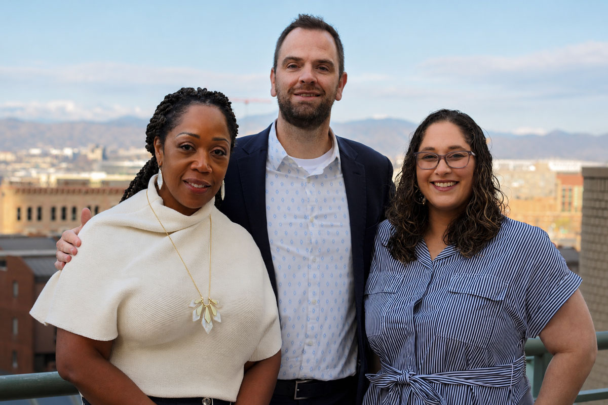 Three people standing together on a balcony
