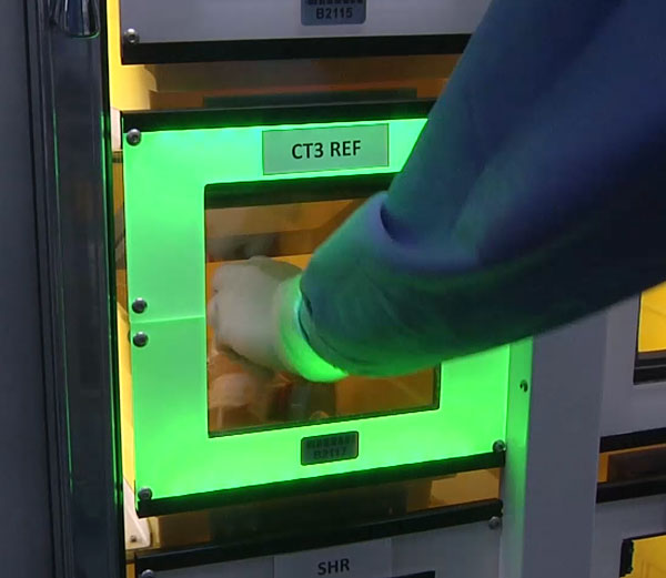 A hand putting a sample in a sort to light area