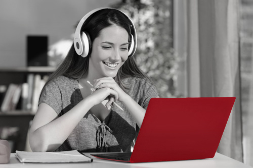 A woman with headphones uses a laptop