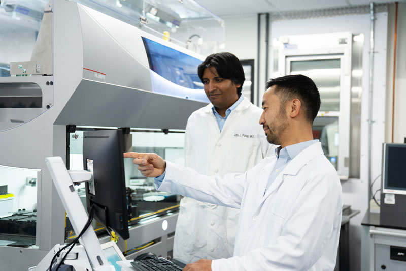 Two men work in a lab