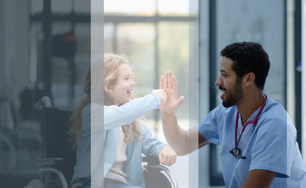 A child in a wheelchair fist bumps a doctor kneeling next to her
